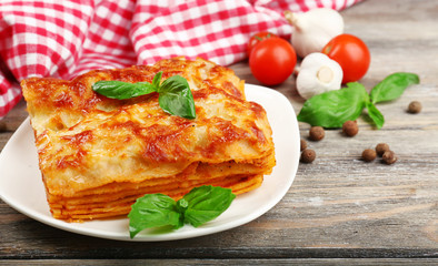 Portion of tasty lasagna on wooden table