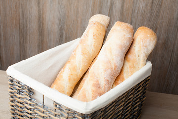 Loafs of traditional French bread baguette stocked in woven bask