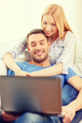 Fototapeta premium smiling happy couple with laptop at home