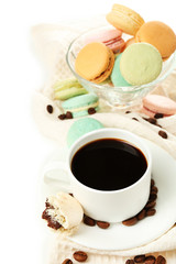Gentle colorful macaroons in glass bowl and black coffee in mug