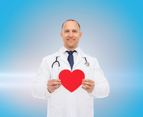 smiling male doctor with red heart and stethoscope