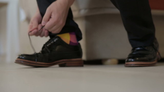 Man's hands tying shoes