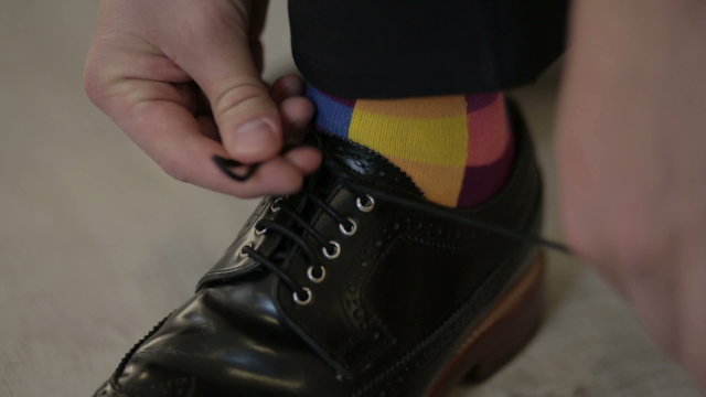 Man's hands tying shoes