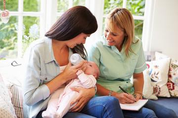 Mother With Baby Meeting With Health Visitor At Home - obrazy, fototapety, plakaty