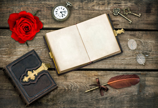 antique books, writing accessories and red rose flower