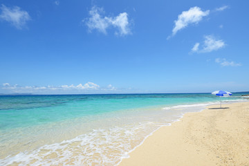 Fototapeta na wymiar 真夏の綺麗なビーチとパラソル