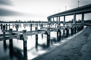 Pier posts in the Severn River and the Naval Academy Bridge, in