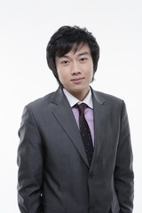 스튜디오 안에서 카메라를 응시하며 서있는 비즈니스맨