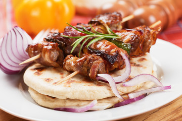 Rolled bacon and meat skewer with pita bread