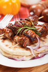 Rolled bacon and meat skewer with pita bread