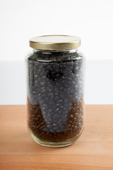 Black beans in a jar on wood table