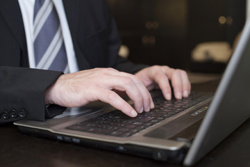 Fototapeta na wymiar Business Man Typing On Laptop Computer Close up