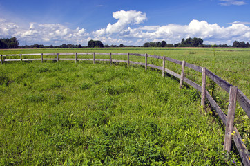 Fototapeta na wymiar farmland landscape with wooden fence