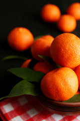 Fresh ripe mandarins on napkin, on wooden background