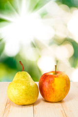 image of an apple and pear on sun background