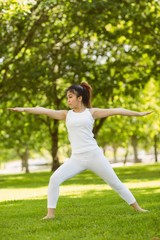 Fototapeta premium Toned woman doing stretching exercises in park