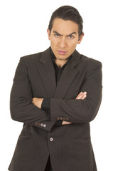 handsome young man wearing a suit posing crossing arms angry