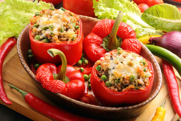 Baked peppers stuffed with meat rice and vegetables on cutting b - obrazy, fototapety, plakaty