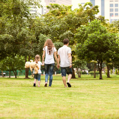 Obraz premium Rodzinny spacer po parku, szczęśliwy o zachodzie słońca w Bangkoku w Tajlandii.