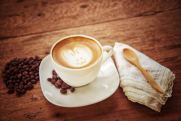 Cup of art latte or cappuccino coffee with retro filter effect