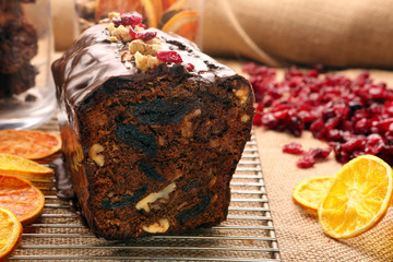 Christmas cake with with dried plums and chocolate icing on wood