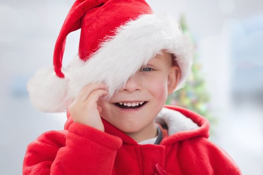 Composite image of cute boy in santa hat