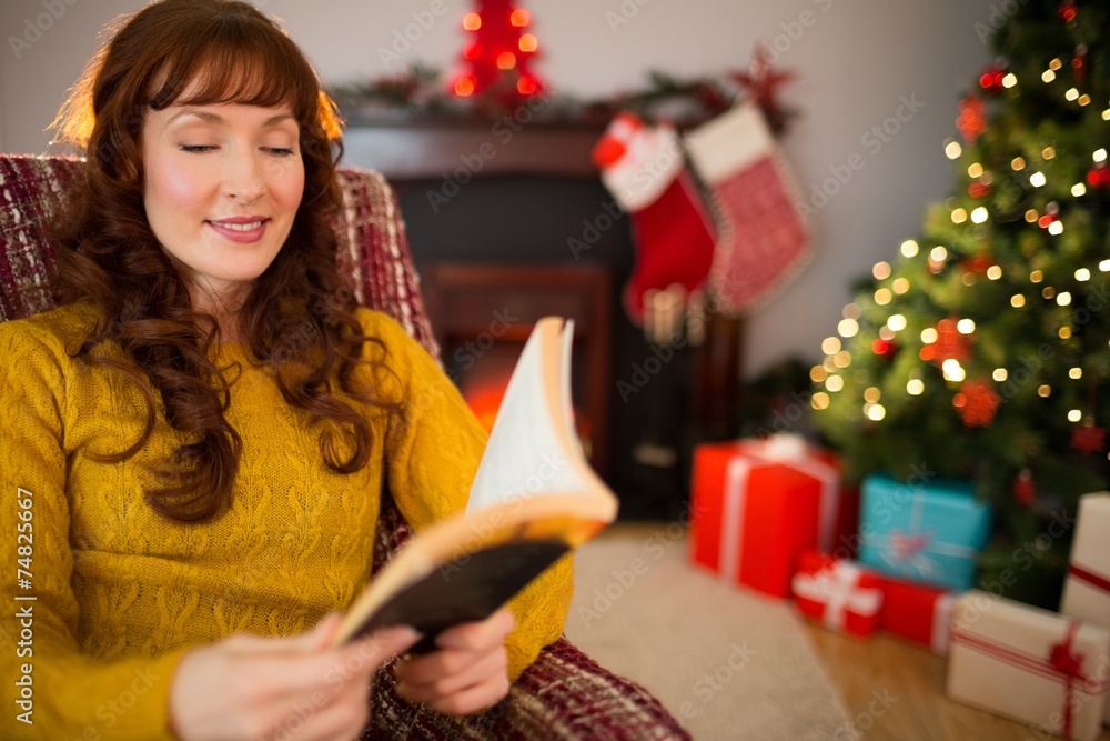 Wall mural cheerful red hair reading a book at christmas