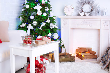 Beautiful Christmas interior with sofa, decorative fireplace