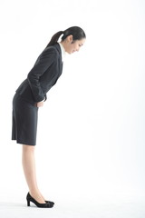 두 손을 모으고 고개 숙여 인사하는 비즈니스 여성