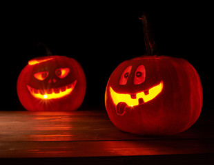 Two glowing jack o lantern pumpkins