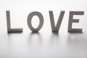  love written in white wooden letters on bright background