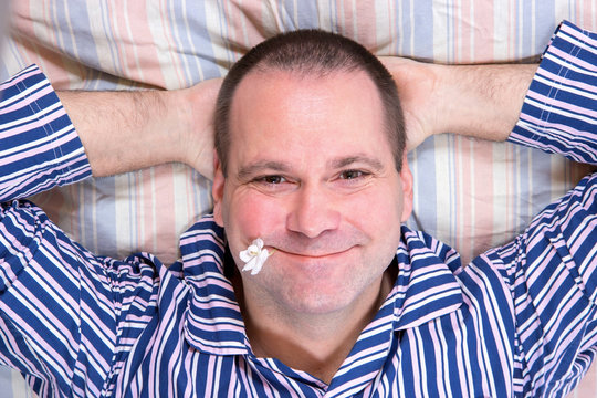 Happy man resting in bed