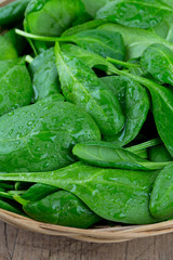 spinach in a basket on wooden surface