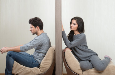Conflict between man and woman sitting on either side of a wall