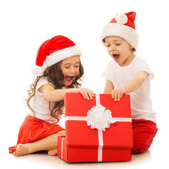 Happy kids in Santa hat opening a gift box