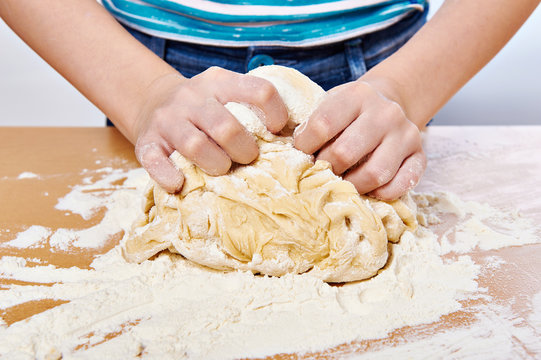 Kneading dough on girl hands