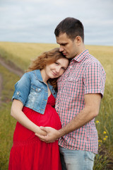 pregnant woman and her husband walking in the countryside