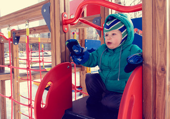 Fototapeta na wymiar little boy having fun in winter playground