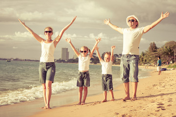 Obraz premium Happy family standing on the beach at the day time.