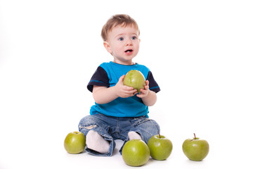 Fototapeta na wymiar Cute baby boy kid eating and playing with green apples