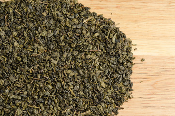 green tea, dried leaves, on wooden background