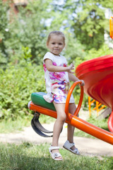 Fototapeta na wymiar Adorable little girl having fun on a swing outdoor