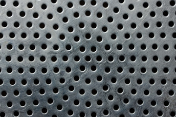 Old metal surface with round holes