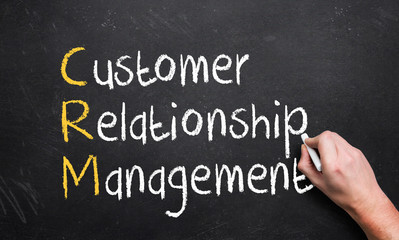 hand writing customer relationship management on a chalk board