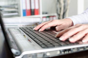 Businesswoman typing on a laptop