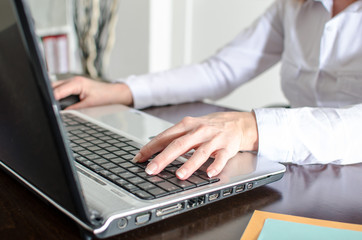 Businesswoman typing on a laptop