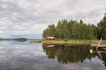 Fototapeta na wymiar Summer in Sweden - traditional red Cottage at a lake 