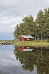 Summer in Sweden - traditional red Cottage at a lake 