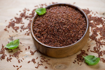 Wooden bowl with red kernel rice, close-up, studio shot