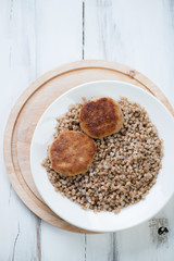 Buckwheat with meat cutlets, above view, vertical shot